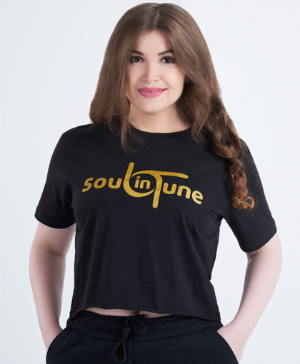 A woman wearing black and gold t-shirt with the words soul in tune.