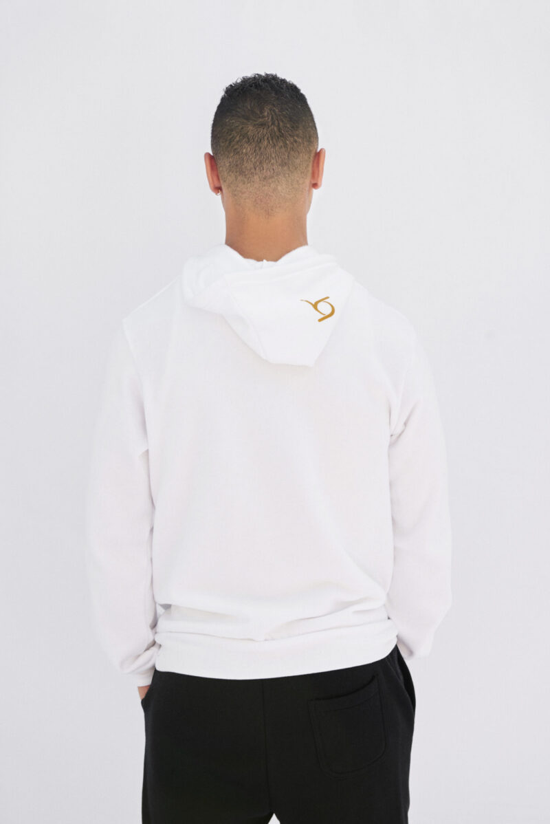 A man wearing white hoodie with gold logo.